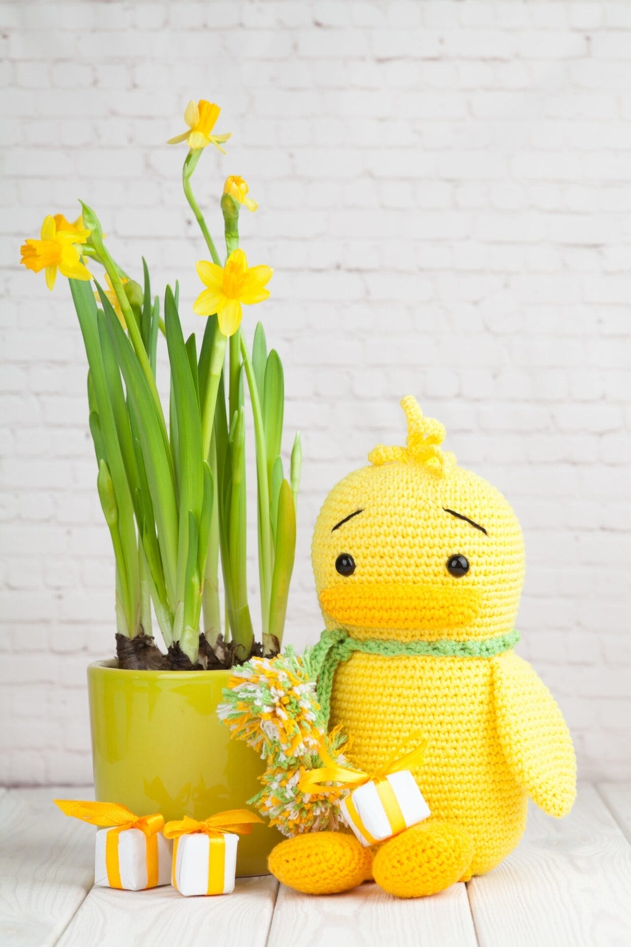 spring easter composition - a pot of daffodils and a knitted duck